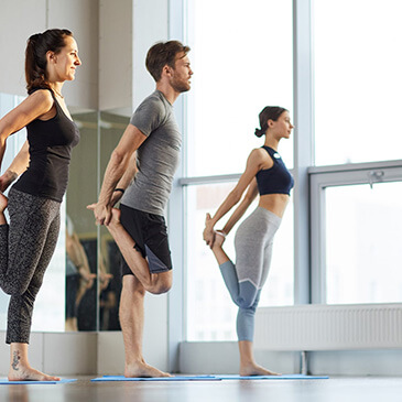 Drei Personen machen Übungen an der Stange.